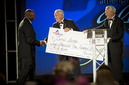 Ameriplan corporation handing out over sized checks to employees at corporate gala Ameriplan corporation CEOs handing out over-sized checks to employees at corporate gala in Texas
