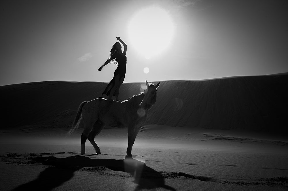 Female model standing on horse in the Great Sand Dunes National Park