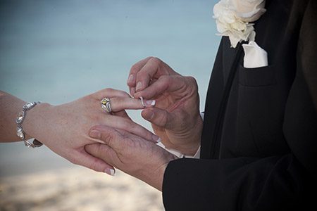 Putting the ring on the bride's hand Groom putting the ring on the bride's hand in the Bahamas