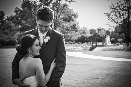 bride and groom holding each other in a park Black and white image of bride and groom holding each other in a park in Nashville