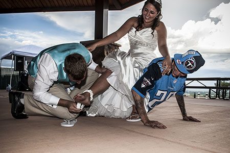 Groom pulling the garter off the bride's leg Groom pulling the garter off the bride's leg as the bride sits on the best man's back out in Nashviile